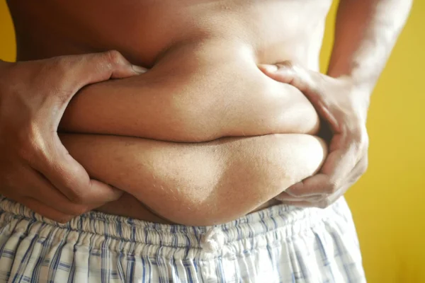 صورة رجل يمسك بطنه لمقالة ايهما افضل التكميم ام تحويل المسار المصغر