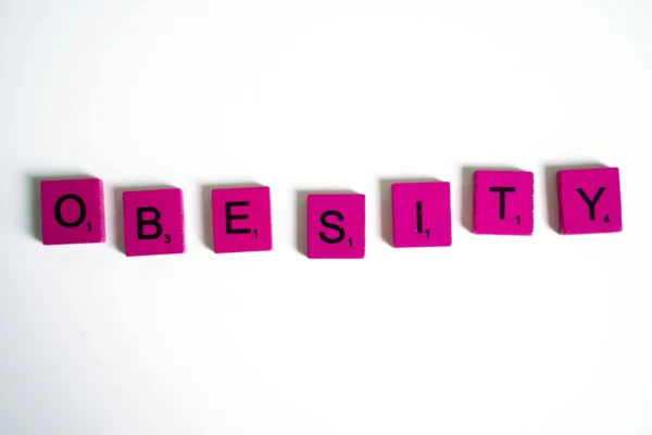 Obesity Spelled on Purple Scrabble Tiles for a blog about fighting childhood obesity