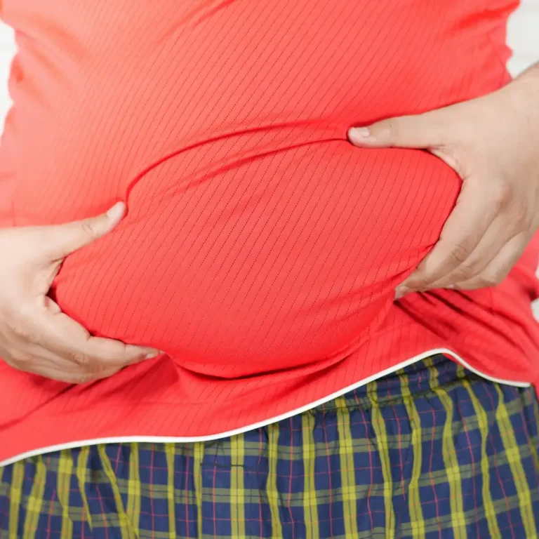 صورة رجل يمسك ببطنه لمقالة عن أضرار السمنة